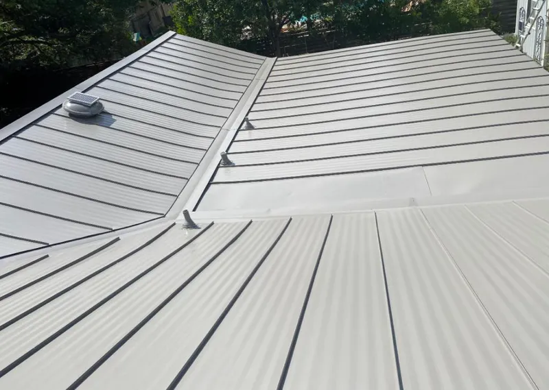 Solar attic fan installed on a metal roof for Roof Ventilation in Ridgewood village