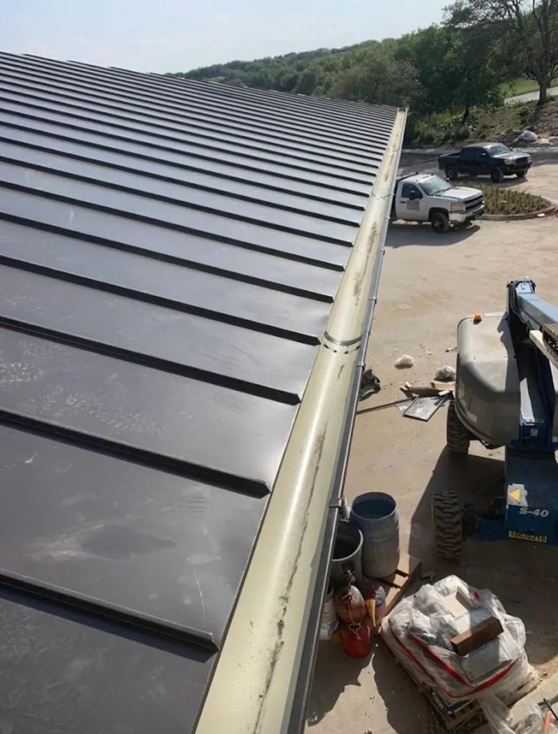 Standing seam panel and gutter detail on a metal roofing jobsite in Ridgewood village